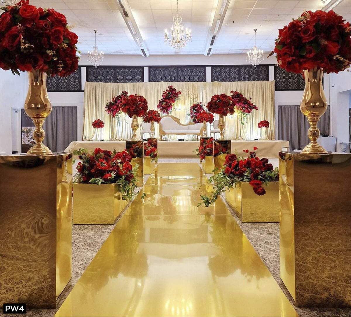 Gold aisle with tall red floral pillars