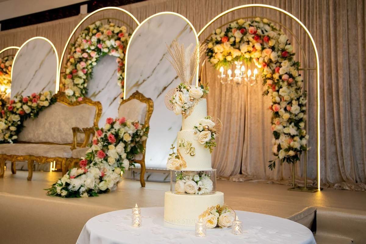Marble arch stage with wedding cake and floral columns