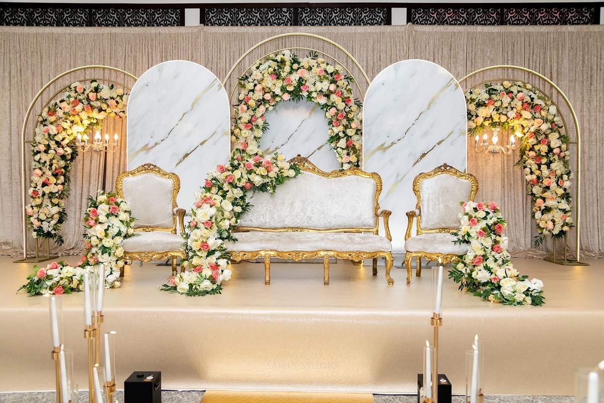 White and gold marble stage framed by floral arches