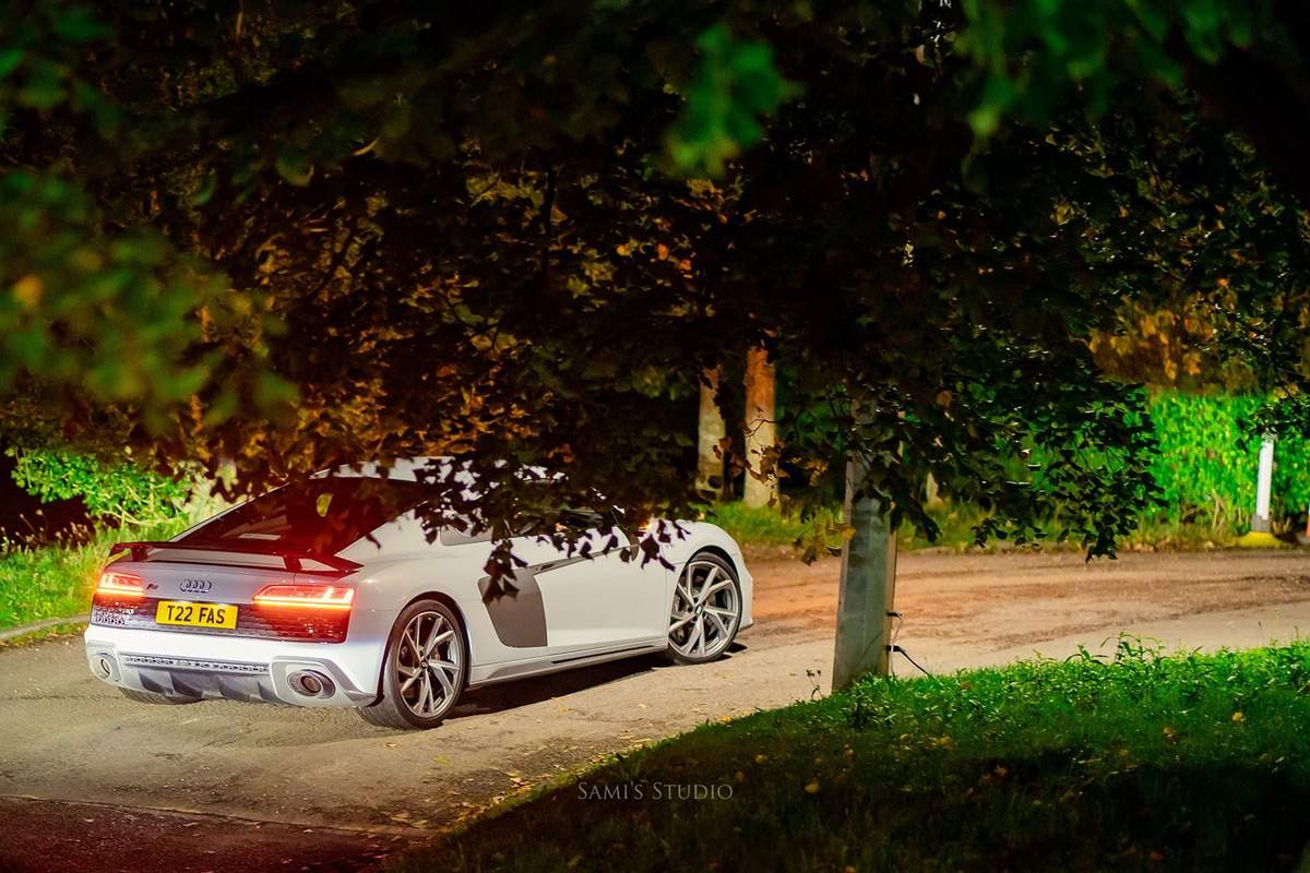 White sports car under the trees at the venue