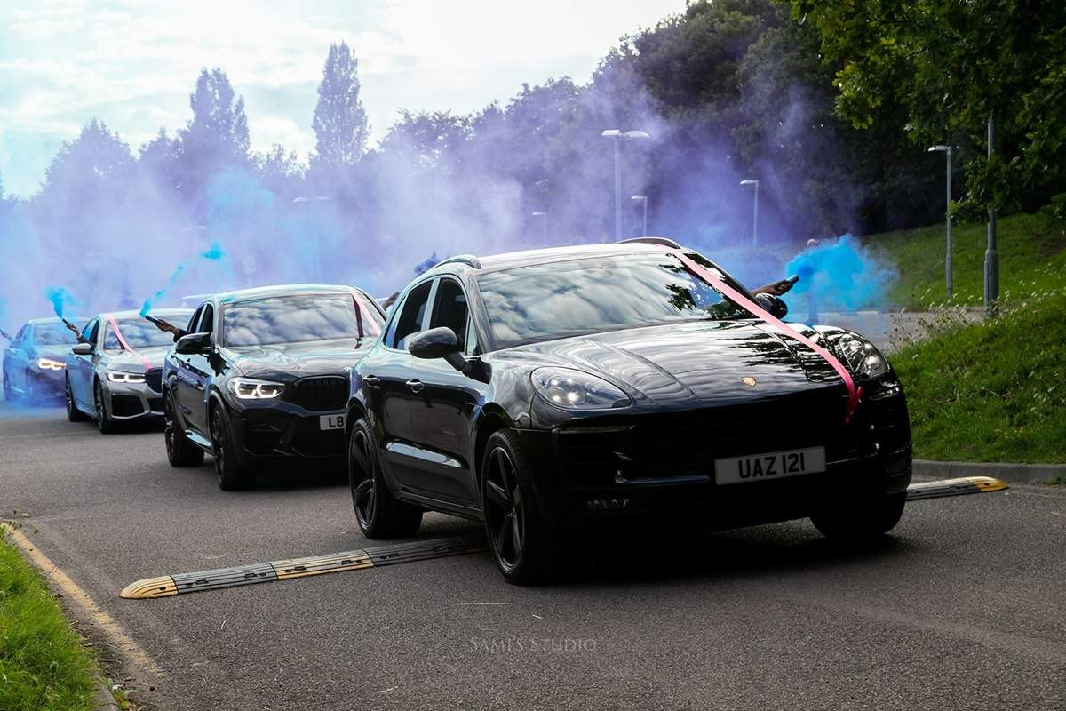 Wedding cars departing with a blue smoke celebration
