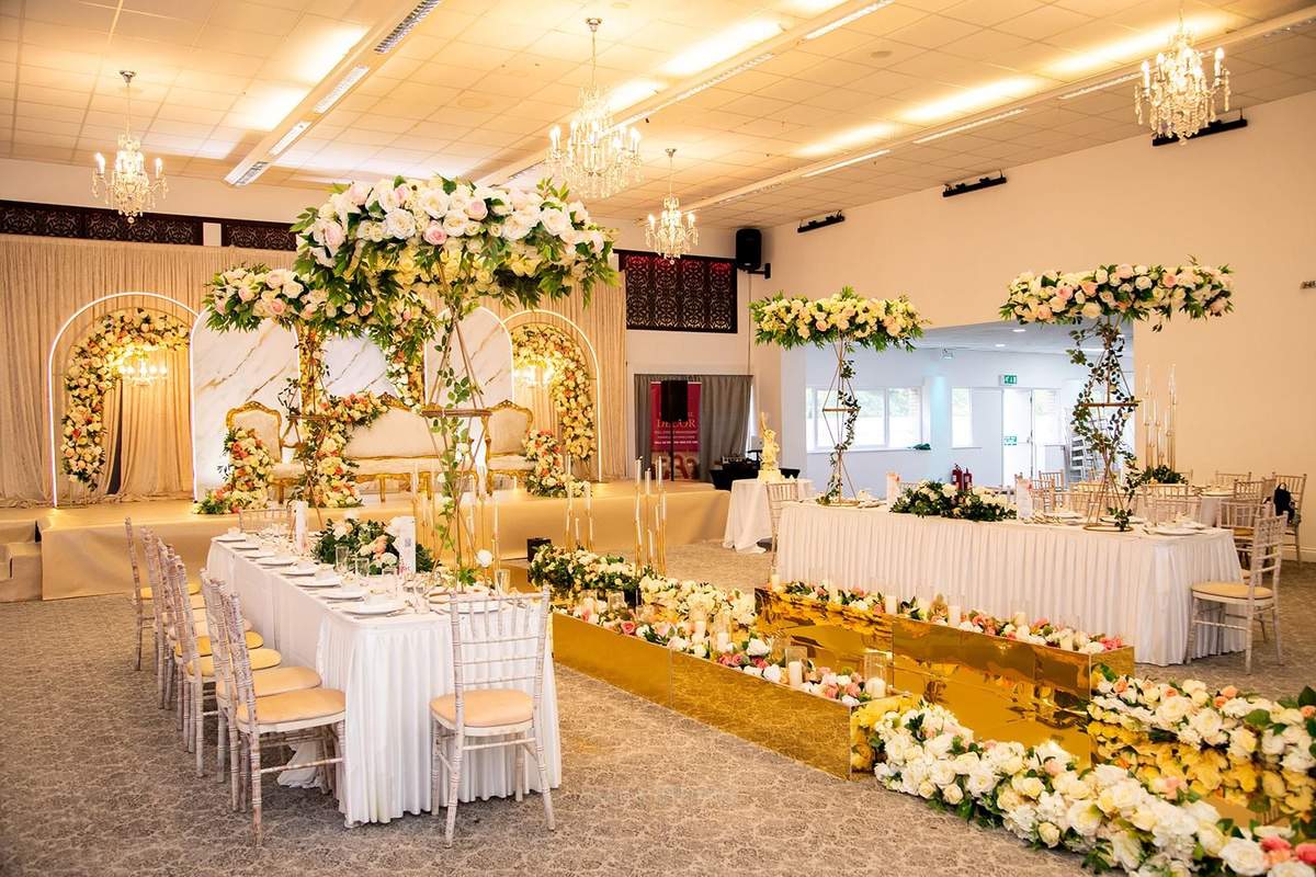 Floral aisle leading toward a gold stage in the Grand Hall