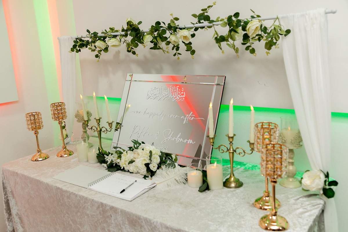 Guest-book table with gold candlesticks and white florals